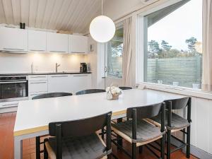 a kitchen with a large white table and chairs at 6 person holiday home on a holiday park in Gilleleje in Gilleleje