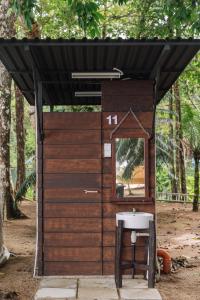 a wooden out house with a mirror and a sink at Roxy Sematan & Telok Serabang in Sematan