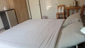 uma cama com lençóis brancos num quarto em คุณเก้า รีสอร์ท 
