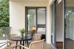un balcone con tavolo, sedie e letto di Stylish 2-Bed, 2-Bath with Parking in Lane Cove a Sydney