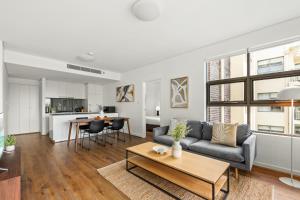 un soggiorno con divano e tavolo di Stylish 2-Bed, 2-Bath with Parking in Lane Cove a Sydney