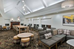 a waiting room with a couch and a table and chairs at Residence Inn Mobile in Mobile