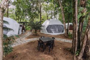 een tafel en stoelen voor twee tenten bij Roxy Sematan & Telok Serabang in Sematan