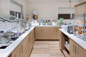 a large kitchen with white counter tops and wooden cabinets at Residence Inn Mobile in Mobile