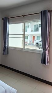 a window with blue curtains in a room at Norrarat Place นรรัตน์ เพลส in Chiang Rai