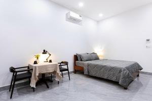 ein Schlafzimmer mit einem Bett, einem Tisch und einem Tisch in der Unterkunft Apartment 152 LVH in Đà Nẵng