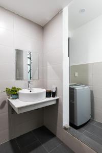 ein Badezimmer mit einem Waschbecken, einer Waschmaschine und einem Trockner in der Unterkunft Apartment 152 LVH in Đà Nẵng