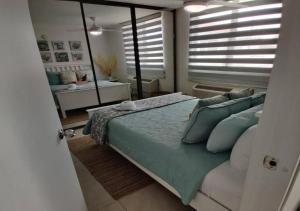 een slaapkamer met een groot bed en een spiegel bij 6-Person BeachFront/Pool Apt at Isabela, PR in Isabela