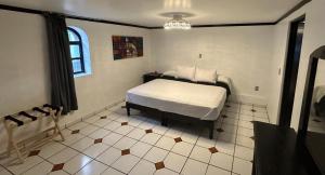 a bedroom with a bed and a tiled floor at HOTEL ZAPOTLAN in Ciudad Guzmán