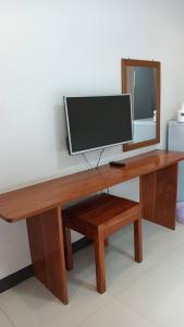 a wooden desk with a television and a mirror at Norrarat Place นรรัตน์ เพลส in Chiang Rai