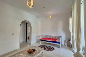 a white room with a bed and a table at Beach Apartment 4 Passi Residence in Watamu