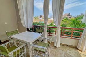 a dining room with a table and chairs and a balcony at Beach Apartment 4 Passi Residence in Watamu