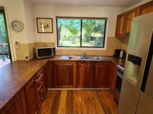a kitchen with wooden cabinets and a sink and a window at Rail Trail Cottage - Bright in Bright +8 photos
