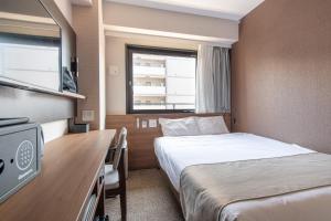 ein Hotelzimmer mit zwei Betten und einem Fernseher in der Unterkunft Hotel Sanrriot Osaka honmachi - Vacation STAY 22289v in Osaka