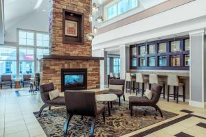 vestíbulo con chimenea, mesa y sillas en Residence Inn by Marriott Yonkers Westchester County, en Yonkers