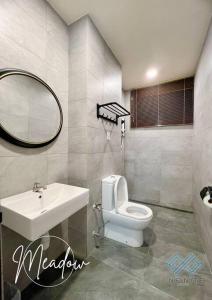 a bathroom with a sink and a toilet and a mirror at Meadow@ Armadale Residence 2BR in Kuching