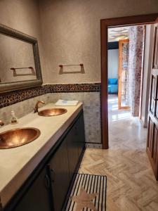 a bathroom with two sinks and a mirror at Charming villa: serenity and style in Marrakesh