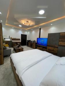 a bedroom with a large bed and a living room at رال هاوس in Al Wajh