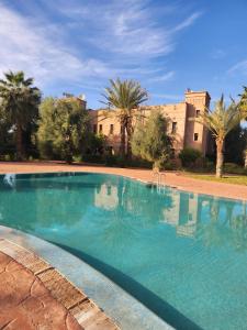 a large swimming pool in front of a building at Charming villa: serenity and style in Marrakesh