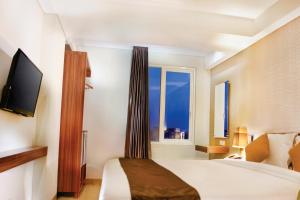 H Boutique Hotel Jogjakarta في يوغياكارتا: غرفه فندقيه بسرير ونافذه