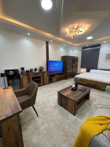 ein Wohnzimmer mit einem Bett und einem TV in der Unterkunft رال هاوس in Al Wajh
