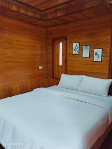 two beds in a bedroom with wood paneling at Song Lay Resort, Koh Mook, Trang THAILAND in Koh Mook