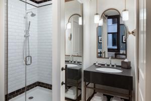 a bathroom with two sinks and a shower at Hotel David Whitney, Autograph Collection in Detroit