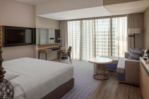 a hotel room with a bed and a living room at Marriott Marquis Dubai in Dubai