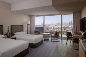 a hotel room with two beds and a view of the city at Marriott Marquis Dubai in Dubai