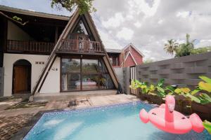 a house with a swimming pool with an inflatablelatable boat at Ubu Villa Kinanthi in Bedoyo