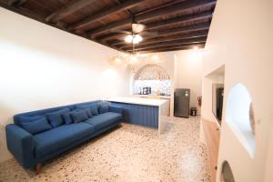 a living room with a blue couch in a room at Ubu Villa Kinanthi in Bedoyo