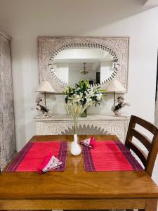 a dining room table with a vase of flowers on it at GG in Imphal