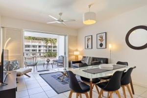 un soggiorno con tavolo e sedie di Fig Oasis—Poolside Resort Living at The Beach Club a Palm Cove