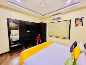 Schlafzimmer mit einem weißen Bett und einem Schreibtisch in der Unterkunft Hotel Grand Bhagwat, Udaipur in Udaipur