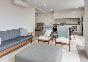 a living room with a couch and chairs and a kitchen at Salt 5 Sorrento walk to beaches shops cafes and restaurants in Sorrento