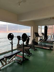 a gym with cardio machines and a large window at Ocean View 2 BR Condo in Tijuana