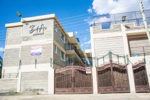 a building with a gate in front of it at Kigoma Suites in Nyahururu