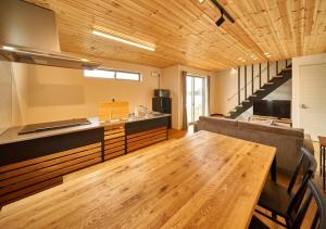 Rakuten STAY HOUSE x WILL STYLE Amakusa 105 pet allowed في Kami Amakusa: مطبخ مع طاولة خشبية طويلة في الغرفة