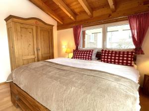 a bedroom with a large bed with red and white pillows at Haus Leni in Fischen
