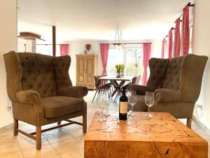a living room with two chairs and a table with wine glasses at Haus Leni in Fischen