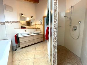 a bathroom with two sinks and a shower at Haus Leni in Fischen