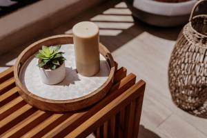 une bougie et une plante en pot sur une table dans l'établissement One Bedroom Apartment By Voyage, à Abu Dhabi