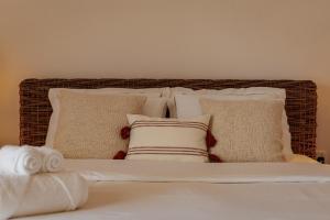 - un lit avec un bouquet d'oreillers dans l'établissement One Bedroom Apartment By Voyage, à Abu Dhabi
