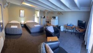 a hotel room with two beds and a living room at Manuka Crescent Motel in Wanaka