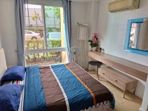 1 dormitorio con cama, ventana y escritorio en Atlantis Condo Resort en Jomtien Beach