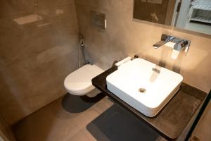 a bathroom with a sink and a toilet at The Opus Kolkata - A Boutique Hotel in Kolkata