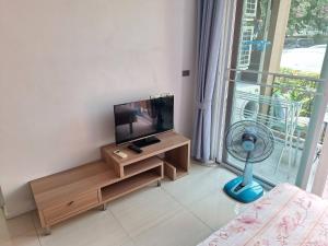 a living room with a flat screen tv and a fan at Atlantis Condo Resort in Jomtien Beach