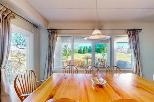 a dining room table with chairs and a large window at Wintergreen 113 in Blue Mountains