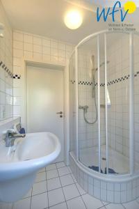 ein Badezimmer mit einer Dusche, einer Badewanne und einem Waschbecken in der Unterkunft Luv und Lee Ferienwohnung Dornbusch in Juist