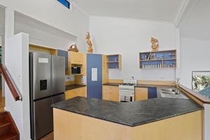 a kitchen with a counter top and a refrigerator at 19 Billa Street in Point Lookout +3 photos